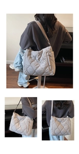 Detailed view of grey quilted puffer shoulder bag with side zipper and wide strap