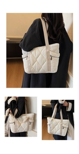 Detail view of quilted puffer tote bag showing side zippers and large capacity