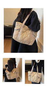 Detailed close-up of quilted tote bag with side silver zipper and wide strap detail