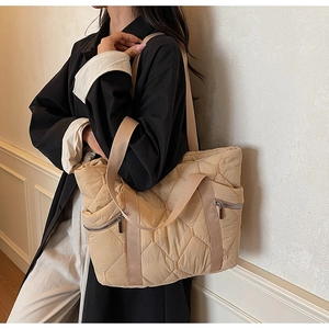 Close-up of quilted pattern and functional side zipper on beige tote bag