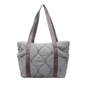 Detail of grey quilted tote bag with side zipper and hexagonal puff texture
