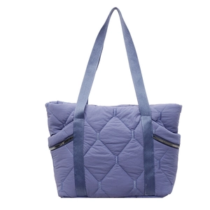 Detailed view of lavender quilted tote bag with side zippers and soft satin finish fabric