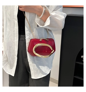 Detail of red glossy mini crossbody bag with gold metal C hardware and chain strap