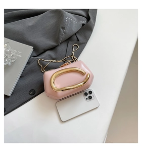 Pink glossy leather crossbody bag with oversized gold C-clasp and slim chain strap