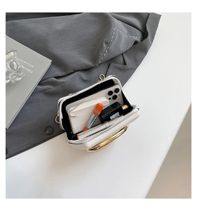 Overhead detail of a white leather handbag interior showing storage for a phone and lipstick