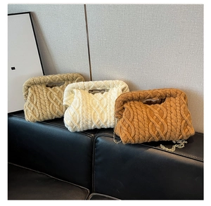 Detailed close-up of chunky knit cosmetic bags in khaki and beige with gold chain straps