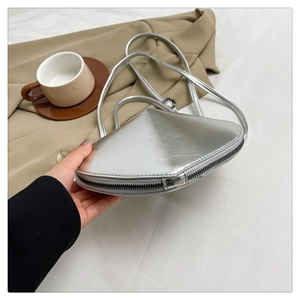Detailed macro view of the silver glossy metallic heart-shaped crossbody bag with zipper