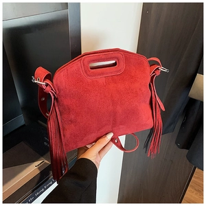 Detailansicht der roten Wildleder-Handtasche mit langen Fransen und hohlem Tragegriff