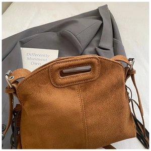 Detailaufnahme der camelfarbenen Wildledertasche mit langen Fransen und ausgeschnittenen Griffen