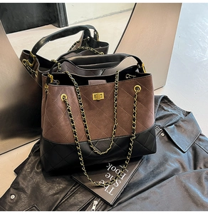 Detailed close-up of brown suede and black leather stitching with gold turn-lock closure