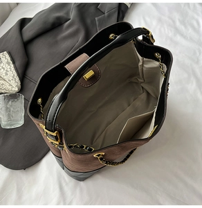 Internal view of large brown suede tote bag featuring quilted texture and gold chain strap