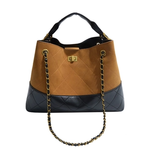 Detail of quilted suede tote with gold-tone metal twist lock and chain strap