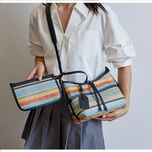 Detail shot of the colorful woven straw bucket bag with matching zipper pouch and black strap