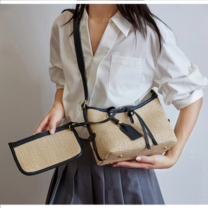 Detail of straw woven shoulder bag and coin purse with black leather trim for summer