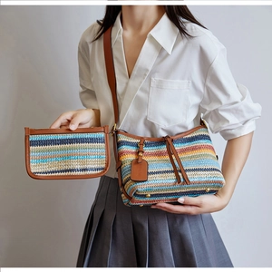 Detail of colorful striped woven bucket bag with brown faux leather strap and tassel accents