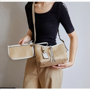 Detail of straw woven bucket bag with cream leather trim and matching small coin purse