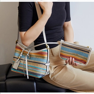 Detail of colorful woven straw bucket bag set with white leather trim and mini pouch