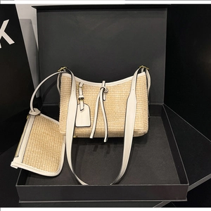 Detail of woven straw bucket bag with white leather trim and matching small pouch