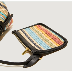 Detail of colorful woven wave pattern with black leather trim and golden zipper