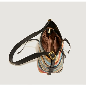 Detail of colorful striped straw bag showing leather strap and striped fabric lining