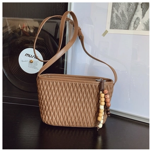 Close-up of brown PU leather bag featuring diamond texture and beaded tassel detail