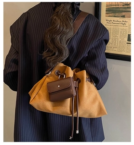 Close-up of yellow drawstring bucket bag with a mini pouch and wide shoulder strap