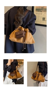 Detail of retro mustard yellow drawstring bucket bag with mini brown pouch and sleek leather texture