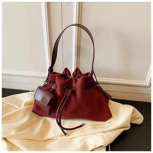 Close-up of wine red suede bucket bag showing drawstring closure and detachable coin purse