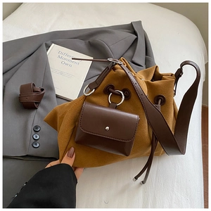Detail of brown suede bucket bag with leather strap, mini pouch and drawstring closure