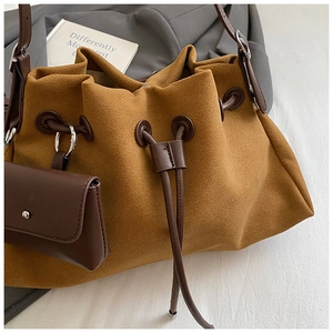 Dettaglio di una borsa a secchiello in pelle scamosciata marrone con mini borsellino