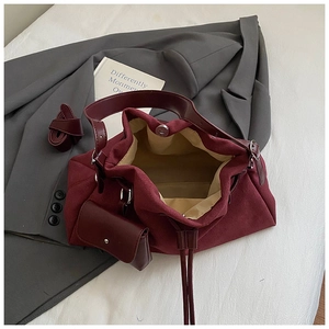 Detail view of burgundy canvas and leather tote set with shoulder strap and mini pouch