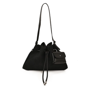 Minimalist black canvas drawstring bucket bag with leather strap and mini pouch charm