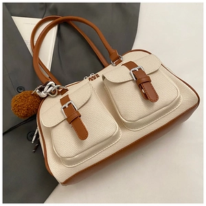 Detail of off-white woven bowling bag with brown leather pockets and plush charm