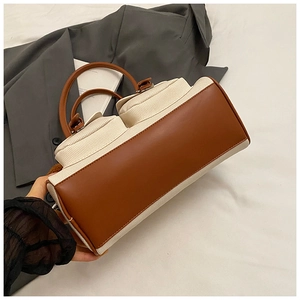 Detail of off-white canvas and brown leather stitching on vintage pillow handbag