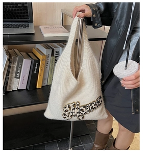 Detailed close-up of fluffy cream tote bag featuring leopard print Happy letter patch