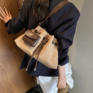 Chic khaki canvas bucket bag with mini leather pouch worn with a navy striped blazer