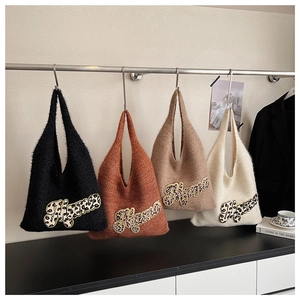 Detail of four knit tote bags featuring leopard print Mama applique on soft fabric
