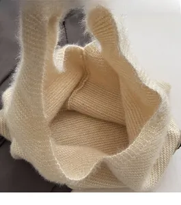 Detail of the open-top design on a beige knit tote bag showing spacious interior