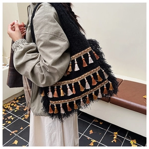 Détails d'un sac cabas en tricot ethnique avec pompons bohèmes et rubans tissés