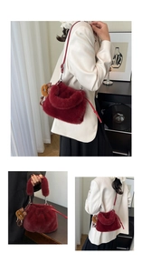 Detail of red plush faux fur bucket bag with thin shoulder strap and leopard charm