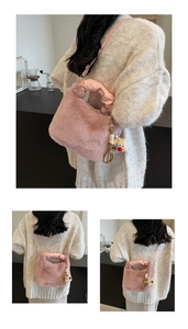 Detail der rosa Plüsch-Eimertasche mit gerafftem Griff und süßem Bären-Anhänger