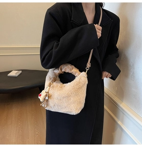 Detailansicht der flauschigen cremefarbenen Handtasche mit gerafftem Griff und Bärenanhänger