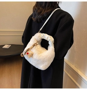 Dettaglio macro della texture di peluche e del ciondolo a orsetto sulla borsa bianca