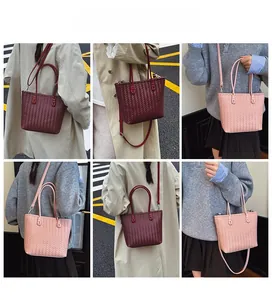 Detail of woven tote bag in burgundy and pink showing crossbody strap and large capacity