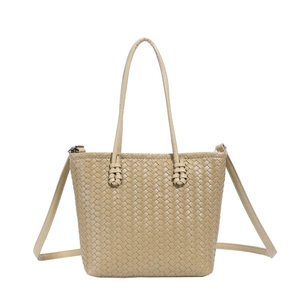 Detail of khaki woven tote bag showing leather texture and adjustable shoulder strap