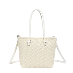 Detailed close-up of woven cream tote bag showing texture and silver hardware hooks