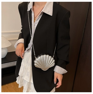Detailed close-up of a silver shell-shaped evening clutch bag with metallic chain strap
