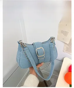 Dettaglio borsa in denim lavato azzurro con fibbia argento e cuciture bianche a vista