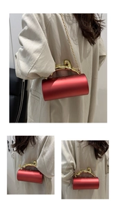 Detail of red cylindrical handbag with a luxury golden leopard-shaped metal handle