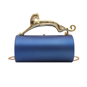 Detailed view of luxury navy blue acrylic evening bag with gold panther handle and chain